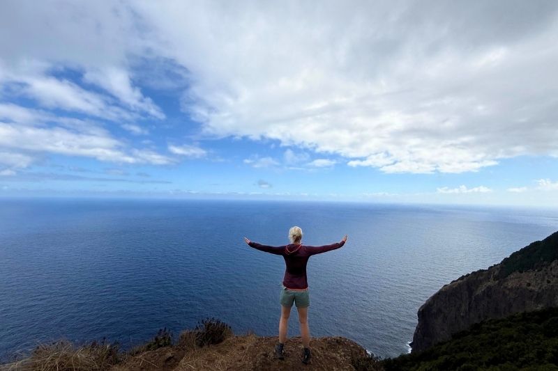Zufrieden auf einer Klippe vor dem offenen Meer