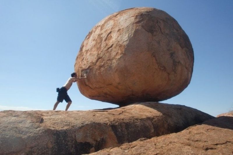 ein Mann wackelt deinen riesigen Felsen
